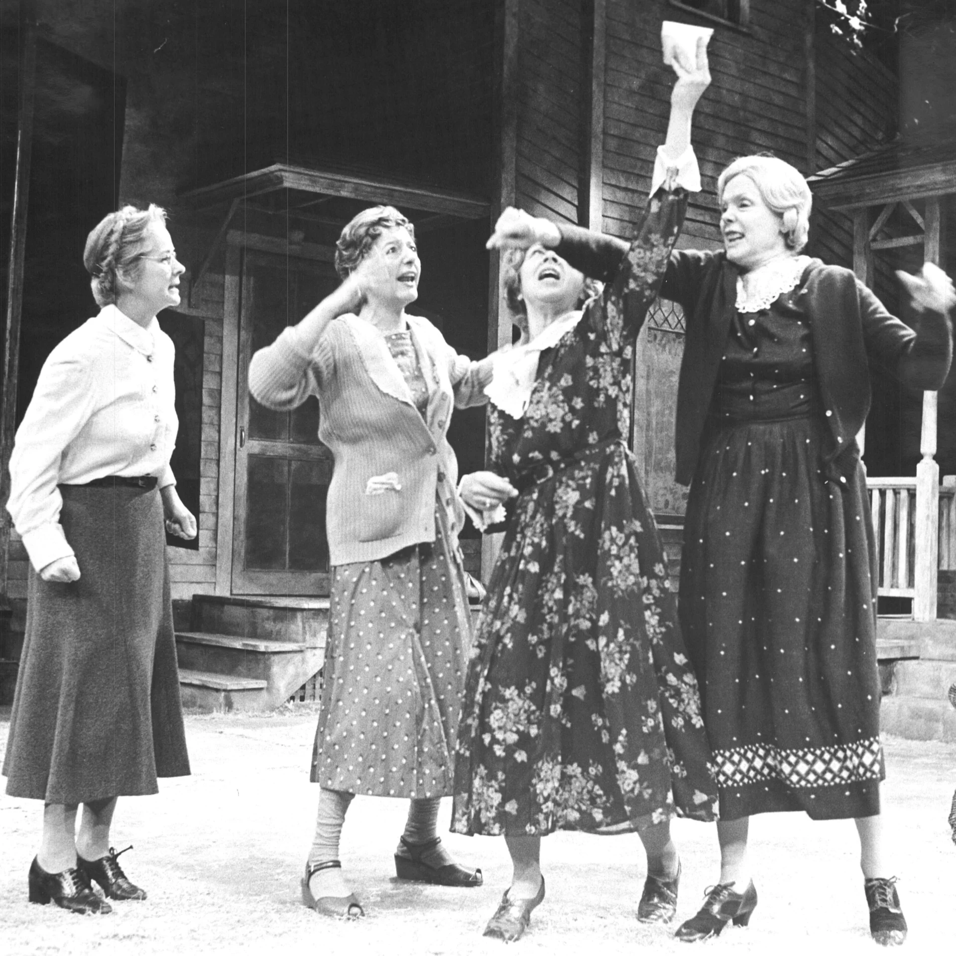 Four woman are seen fist bumping the air.