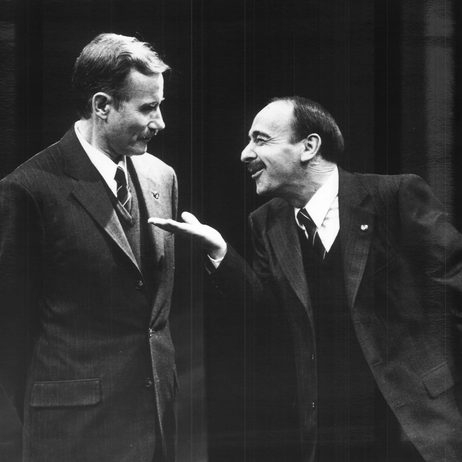 Two men in suits speaking