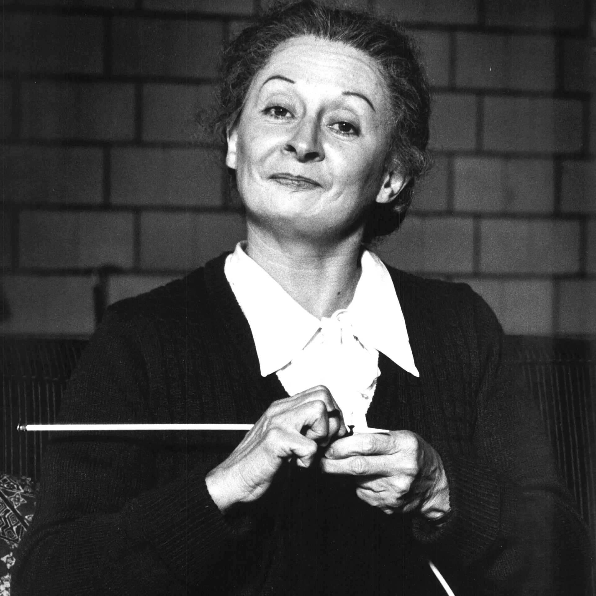 A Woman is Smirking and Knitting