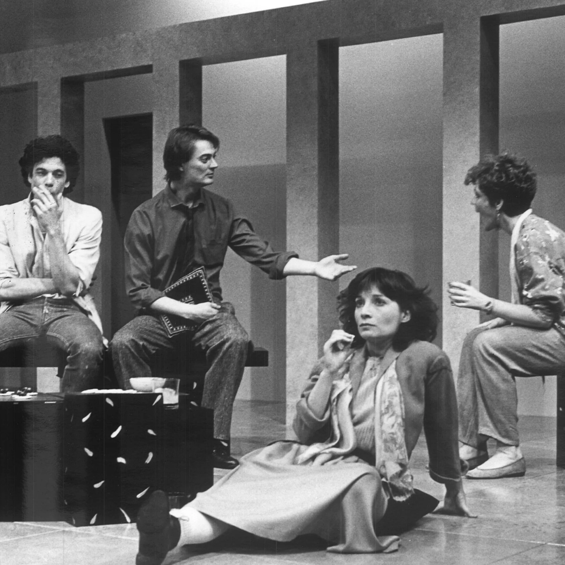 A Man and woman are having a conversation while another man and woman are sitting lost in thought.