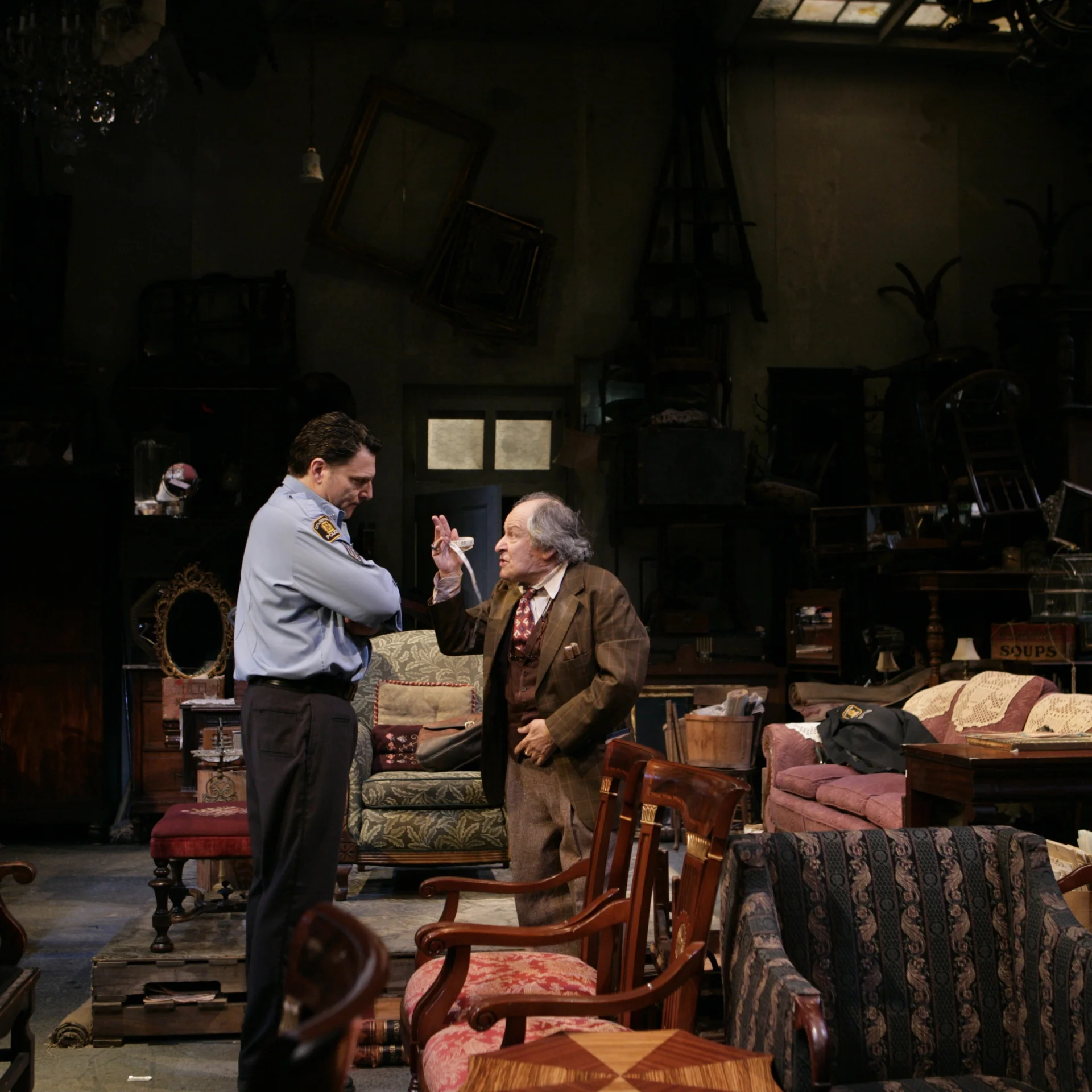 A man holding a tape measure wags his finger at a police officer with his arms crossed