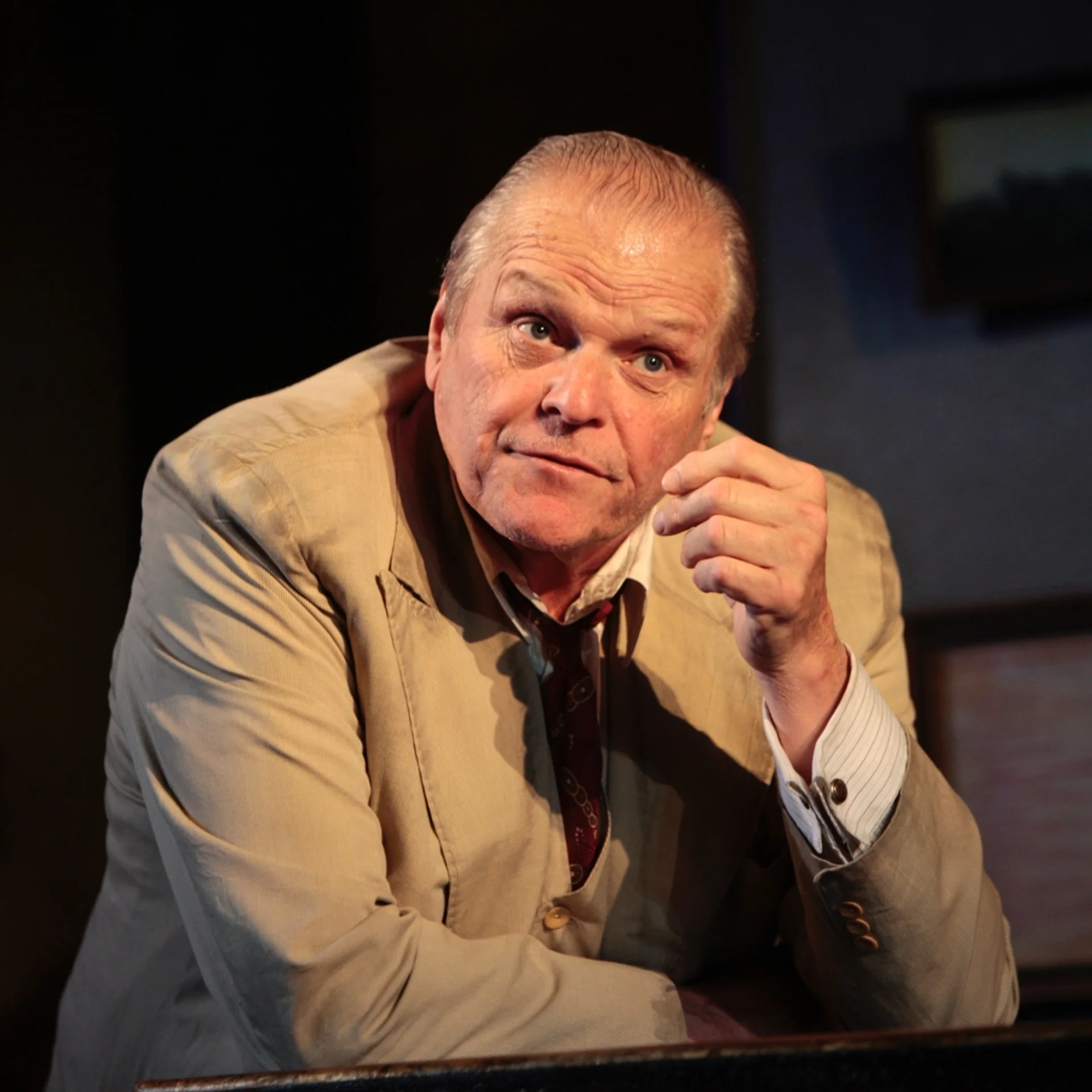 A man leans on his forearm and looks out