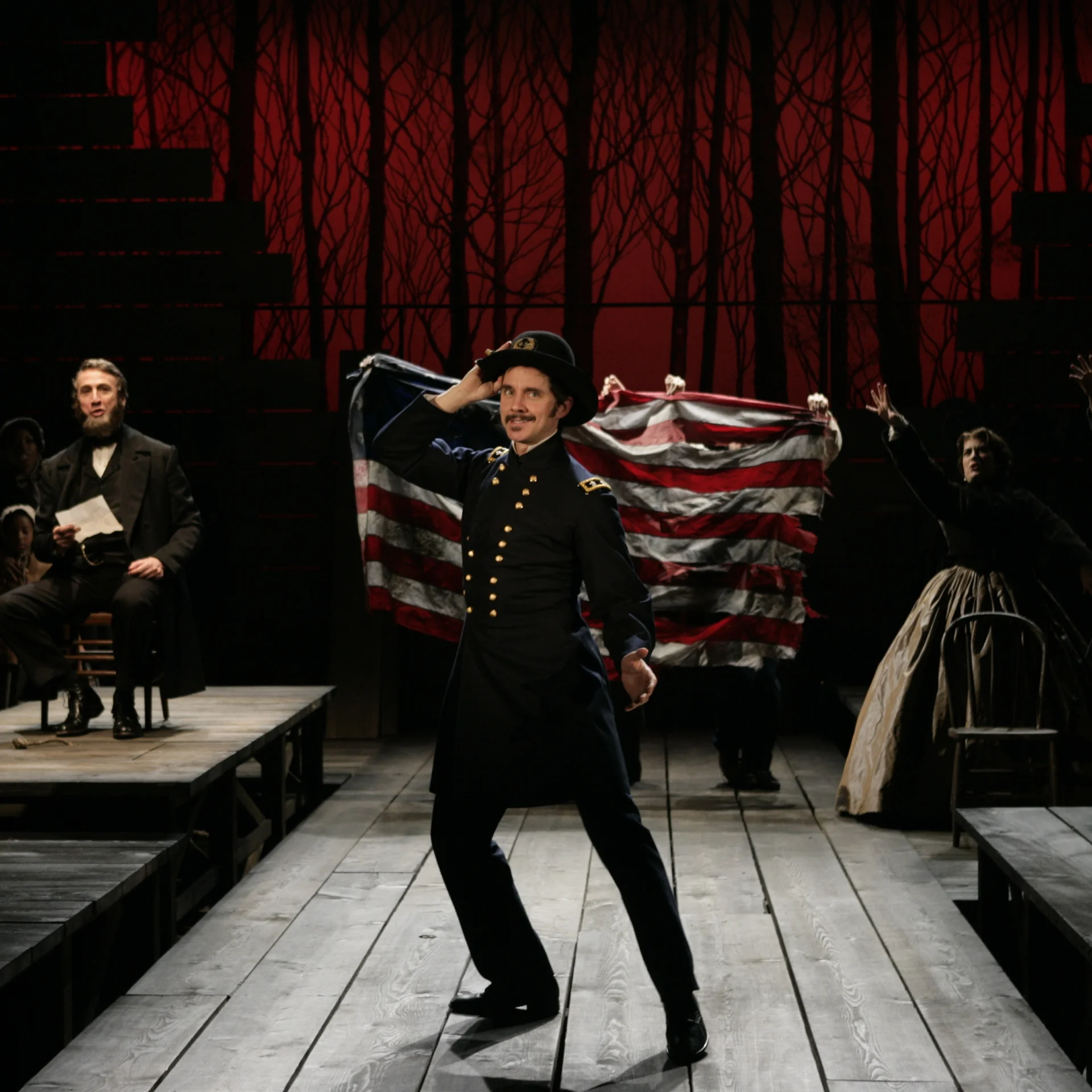 A man in a top hat poses in front of an American flag