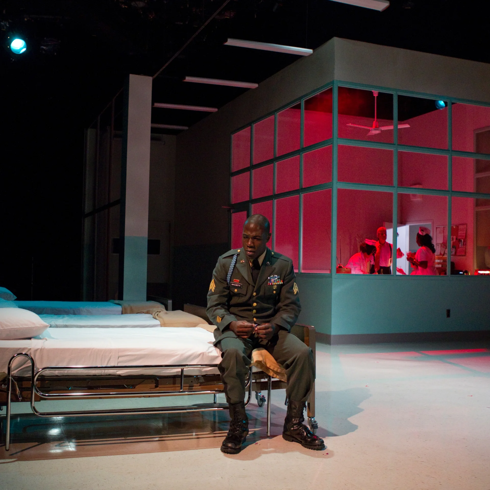 A uniformed man sits on a cot