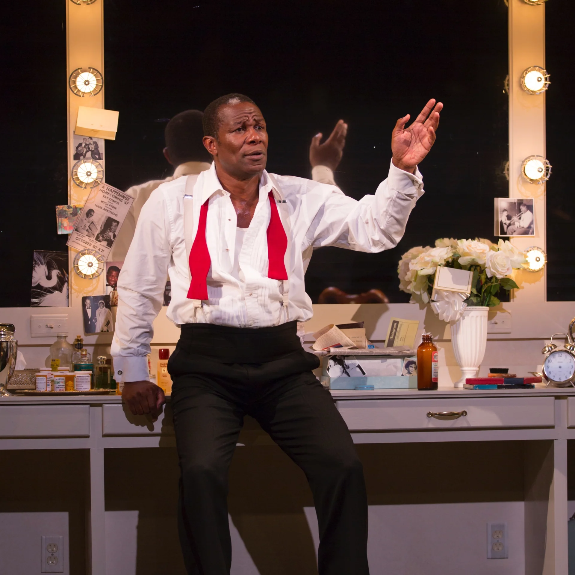 A man with an undone bowtie leans against a dressing room station
